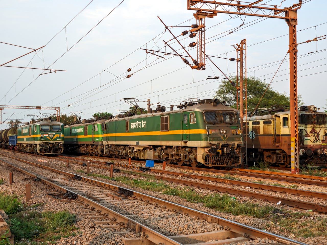Electric locomotives of Indian Railways on tracks during sunset, showcasing the railway infrastructure.